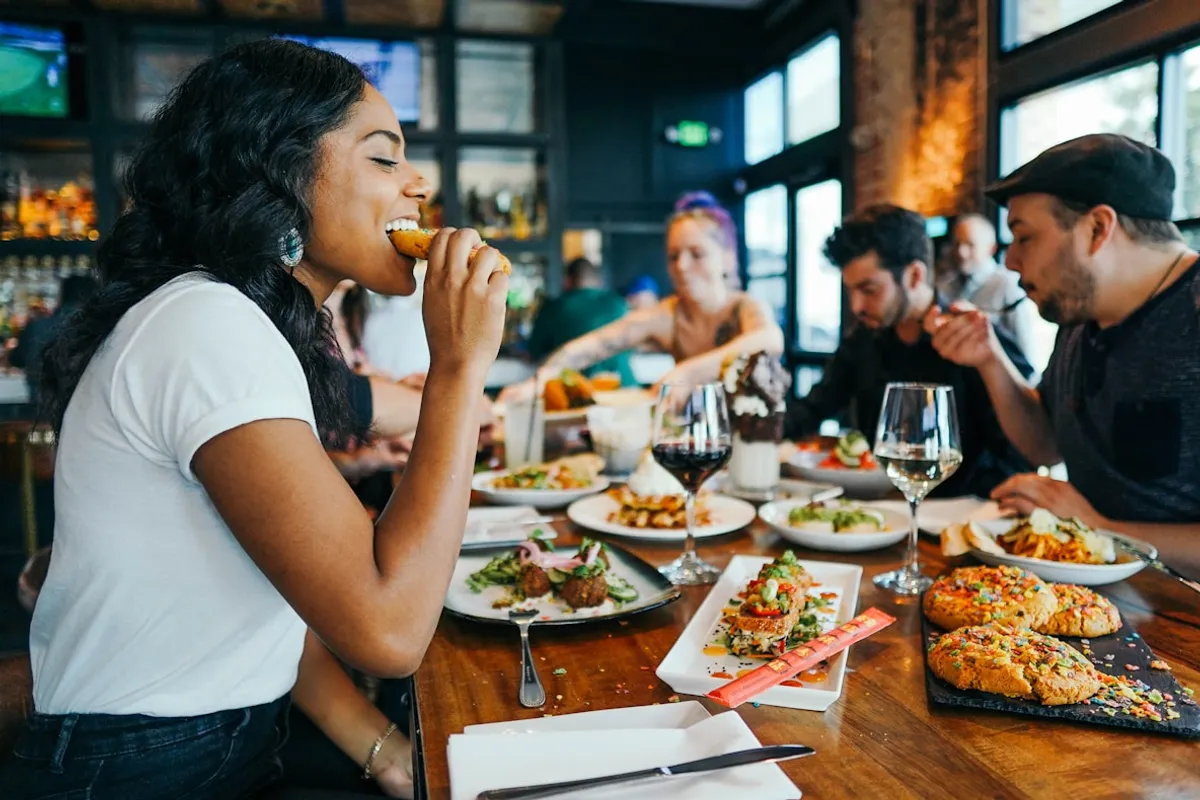 Group of friends enjoying a shared restaurant meal at a bar-style table